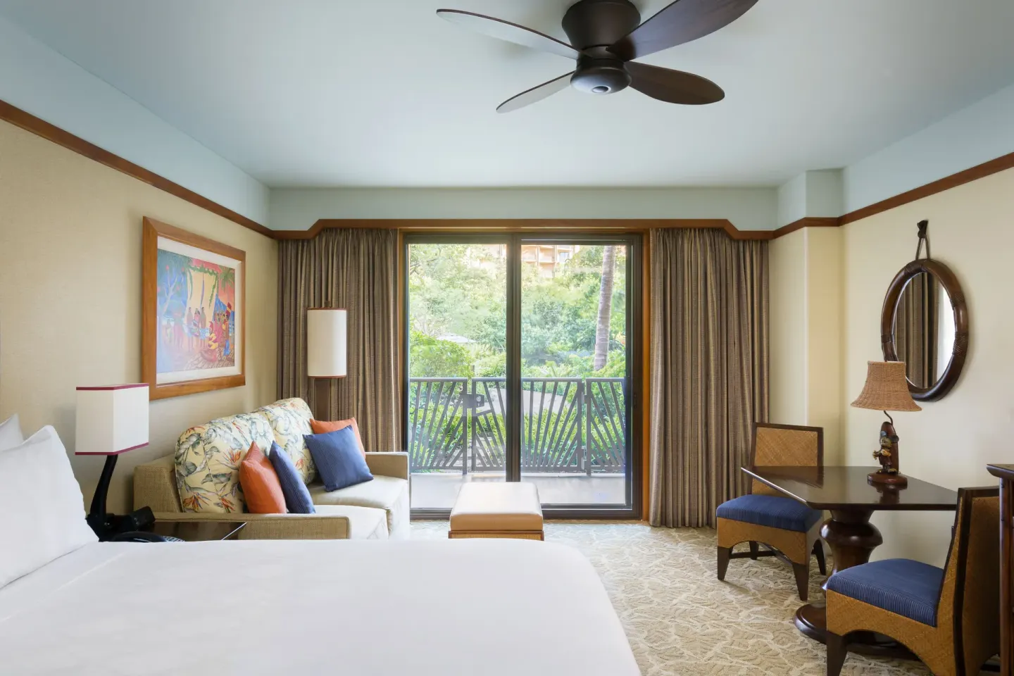 Garden View guest room with bed, sofa, table and balcony at Aulani, A Disney Resort & Spa.