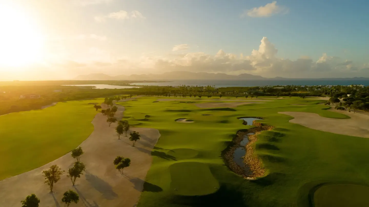 Aerial view of the golf course at Aurora Anguilla Resort & Golf Club in golden sunlight.