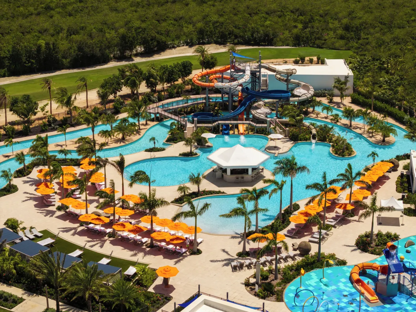 Aerial view of the water park, lazy river, and orange umbrellas at Aurora Anguilla Resort & Golf Club.