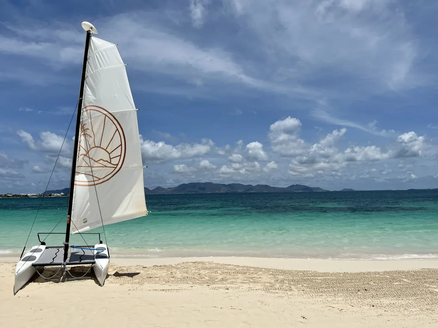 A small sailboat rests on the beach at Aurora Anguilla Resort & Golf Club.