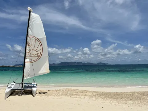 A small sailboat rests on the beach at Aurora Anguilla Resort & Golf Club.