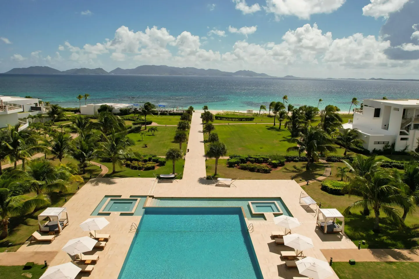 Elevated view of the pool, lawns, beach, and sea at Aurora Anguilla Resort & Golf Club.