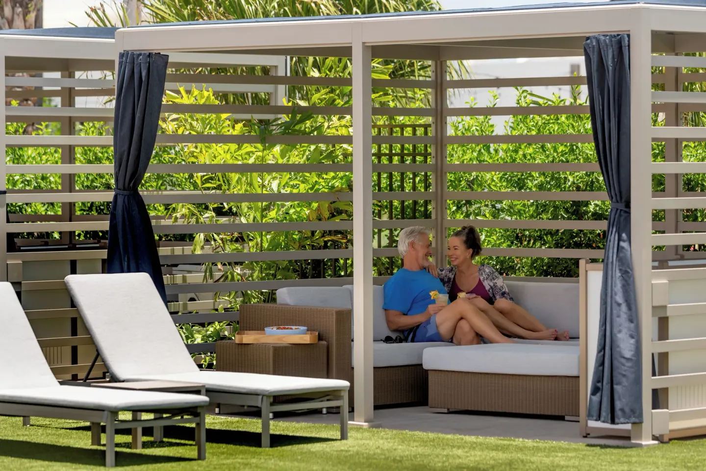 Guests relax in a shaded poolside cabana at Aurora Anguilla Resort & Golf Club.