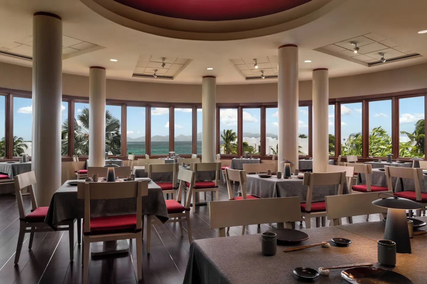 Round dining room with ocean-facing windows at Aurora Anguilla Resort & Golf Club.