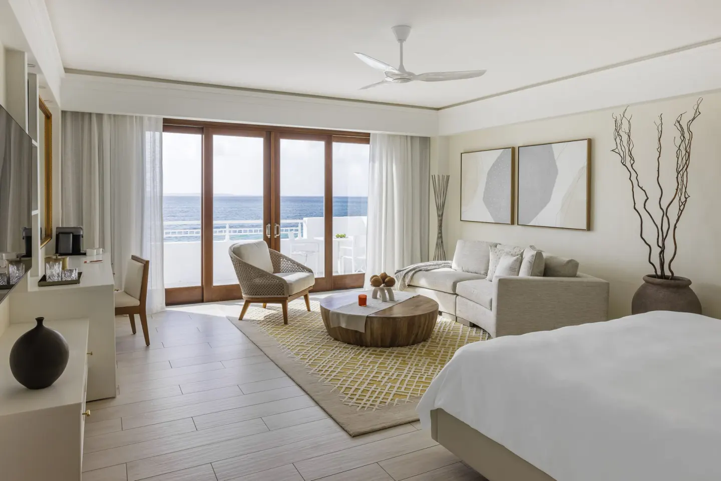 Beachfront Junior Suite with bed, sitting area, and ocean-facing balcony at Aurora Anguilla Resort & Golf Club.