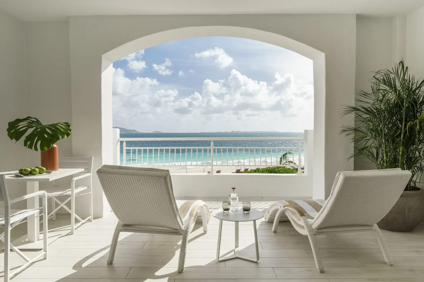 Beachfront Junior Suite terrace with lounge chairs and ocean view at Aurora Anguilla Resort & Golf Club.