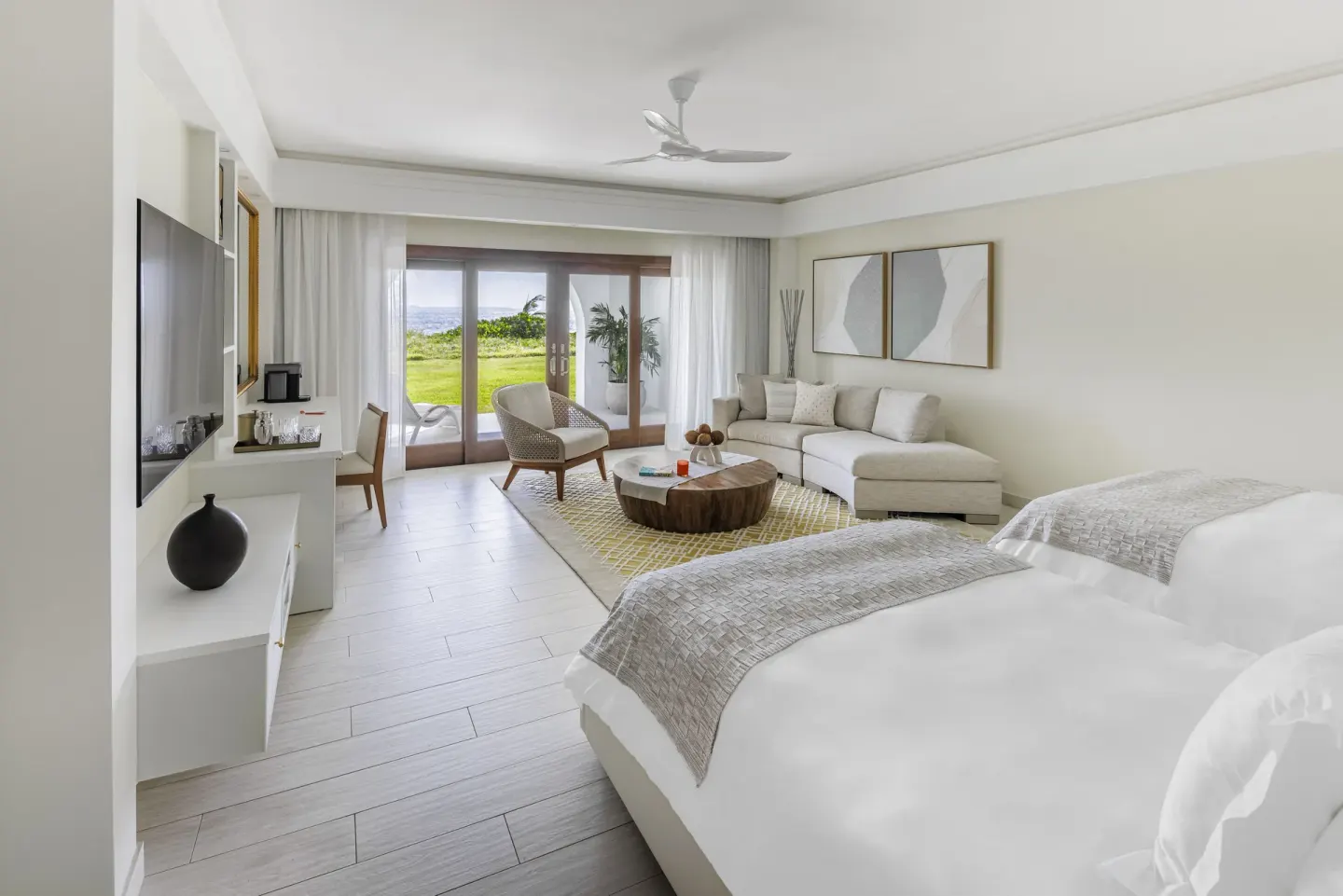 Beachfront Junior Suite Rendezvous Beach with bed and lounge area at Aurora Anguilla Resort & Golf Club.