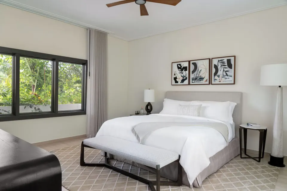 Five Bedroom Garden Villa king bedroom with garden-facing windows at Aurora Anguilla Resort & Golf Club.