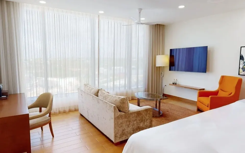 Island View Deluxe Room seating area and bed at Aurora Anguilla Resort & Golf Club.