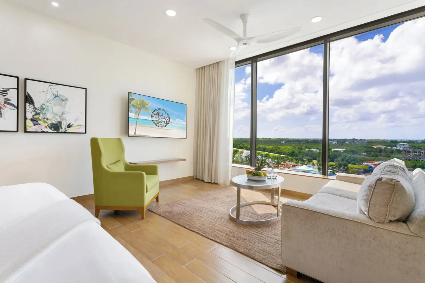 Island View Deluxe Room sofa and green chair by windows at Aurora Anguilla Resort & Golf Club.