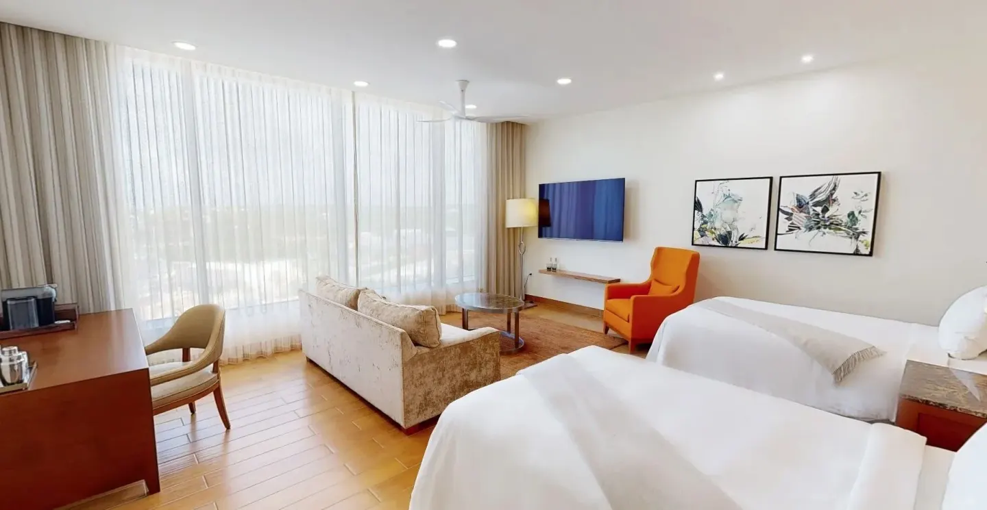 Island View Deluxe Room with two beds and lounge area at Aurora Anguilla Resort & Golf Club.