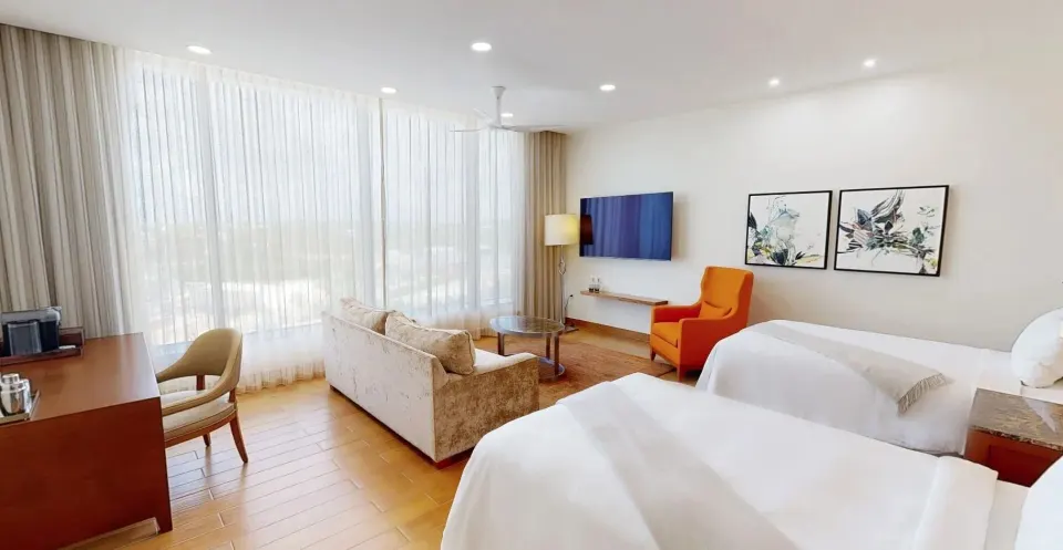 Island View Deluxe Room with two beds and lounge area at Aurora Anguilla Resort & Golf Club.