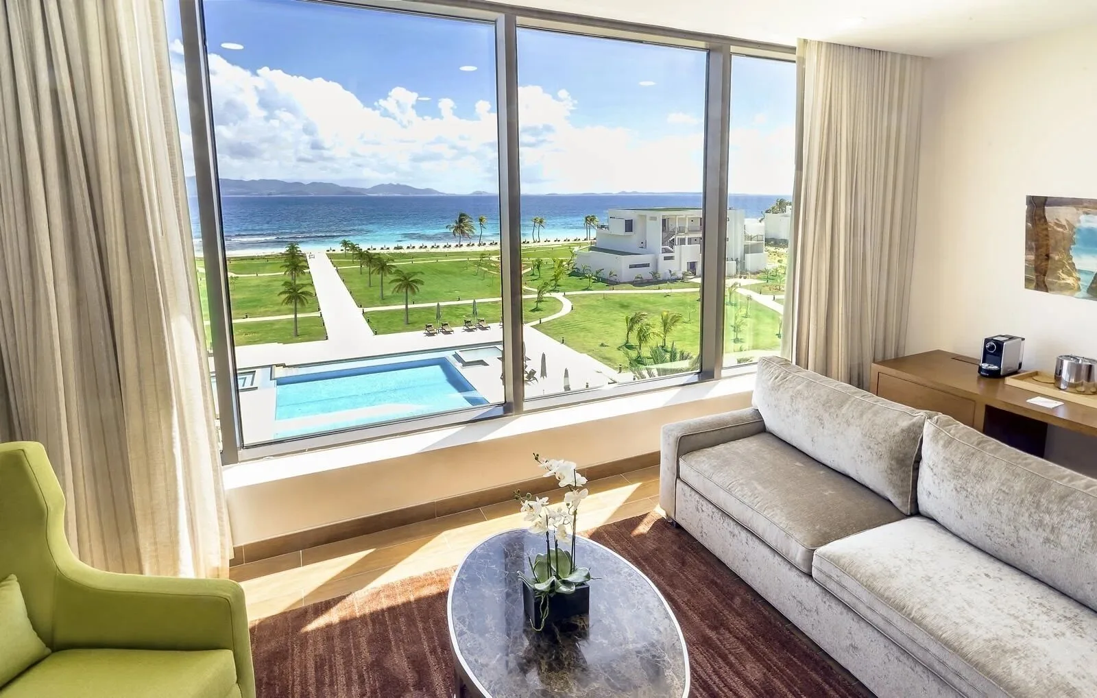 Ocean View Deluxe Room sitting area with sofa and sea view at Aurora Anguilla Resort & Golf Club.