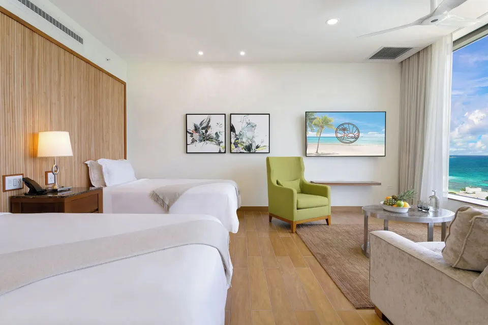 Ocean View Deluxe Room with two beds and sitting area at Aurora Anguilla Resort & Golf Club.