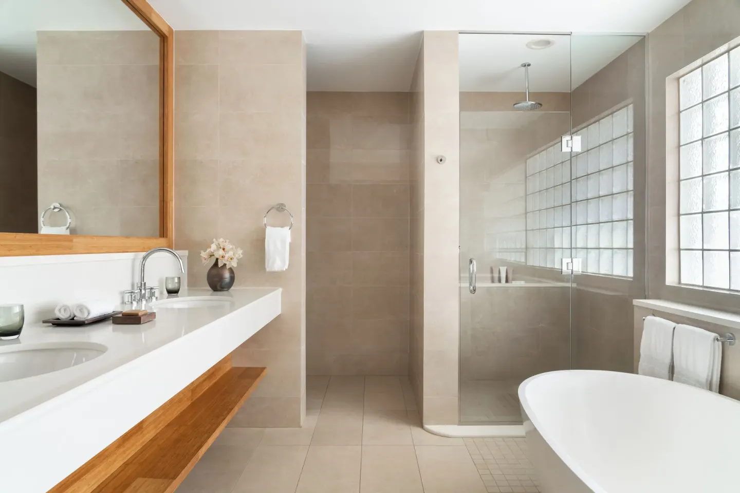 Bathroom with vanity, glass shower, and tub in an Oceanfront Junior Suite at Aurora Anguilla Resort & Golf Club.