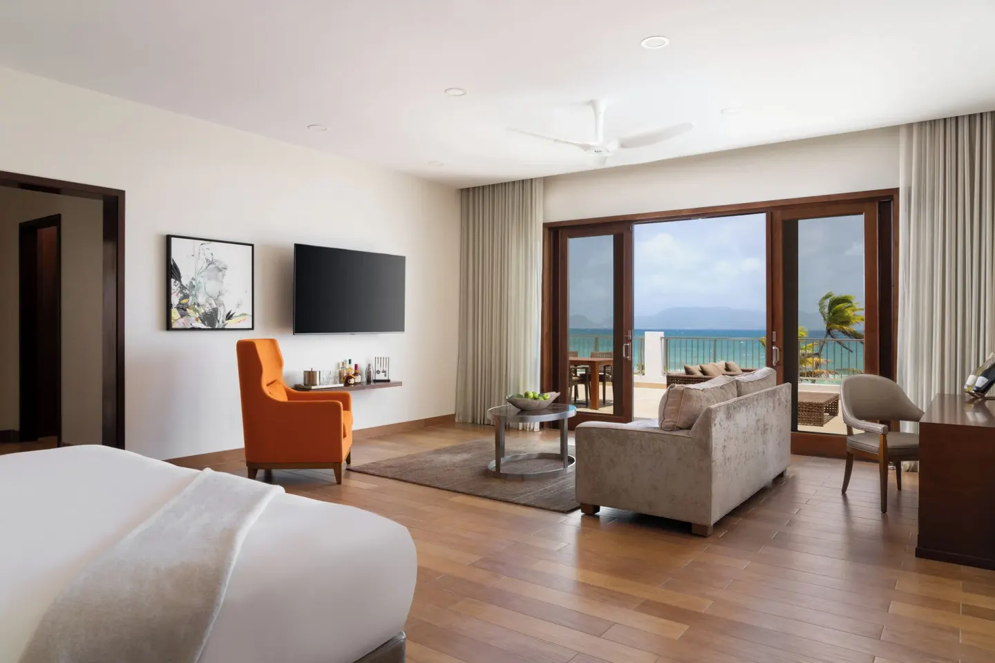 Oceanfront Junior Suite with king bed and balcony seating at Aurora Anguilla Resort & Golf Club.