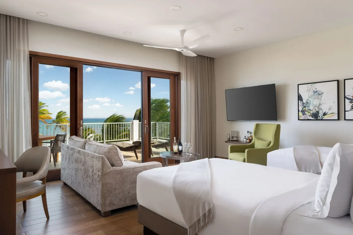 Oceanfront Junior Suite with two beds and terrace doors at Aurora Anguilla Resort & Golf Club.