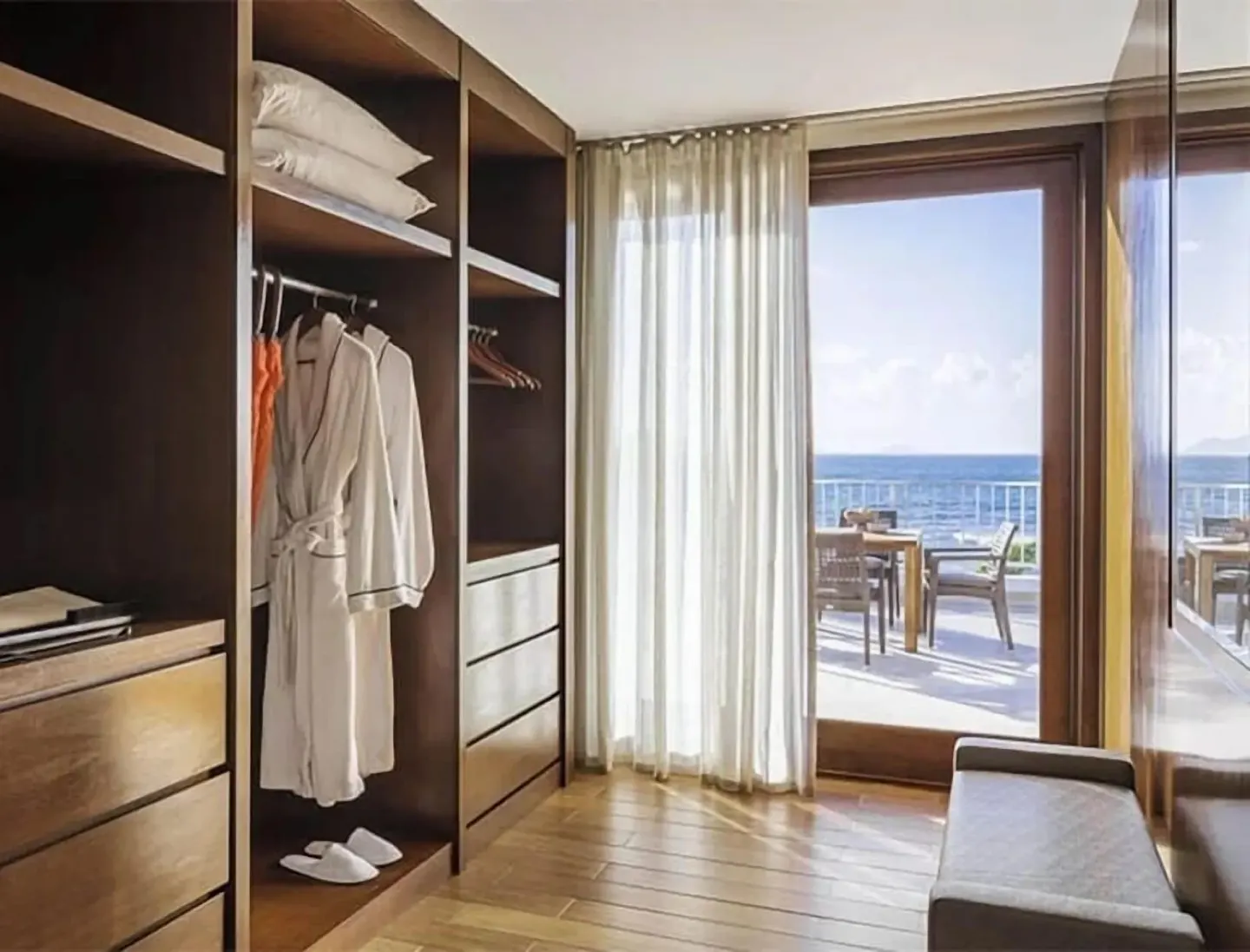 Walk-in closet with robes and ocean-view balcony at Aurora Anguilla Resort & Golf Club.