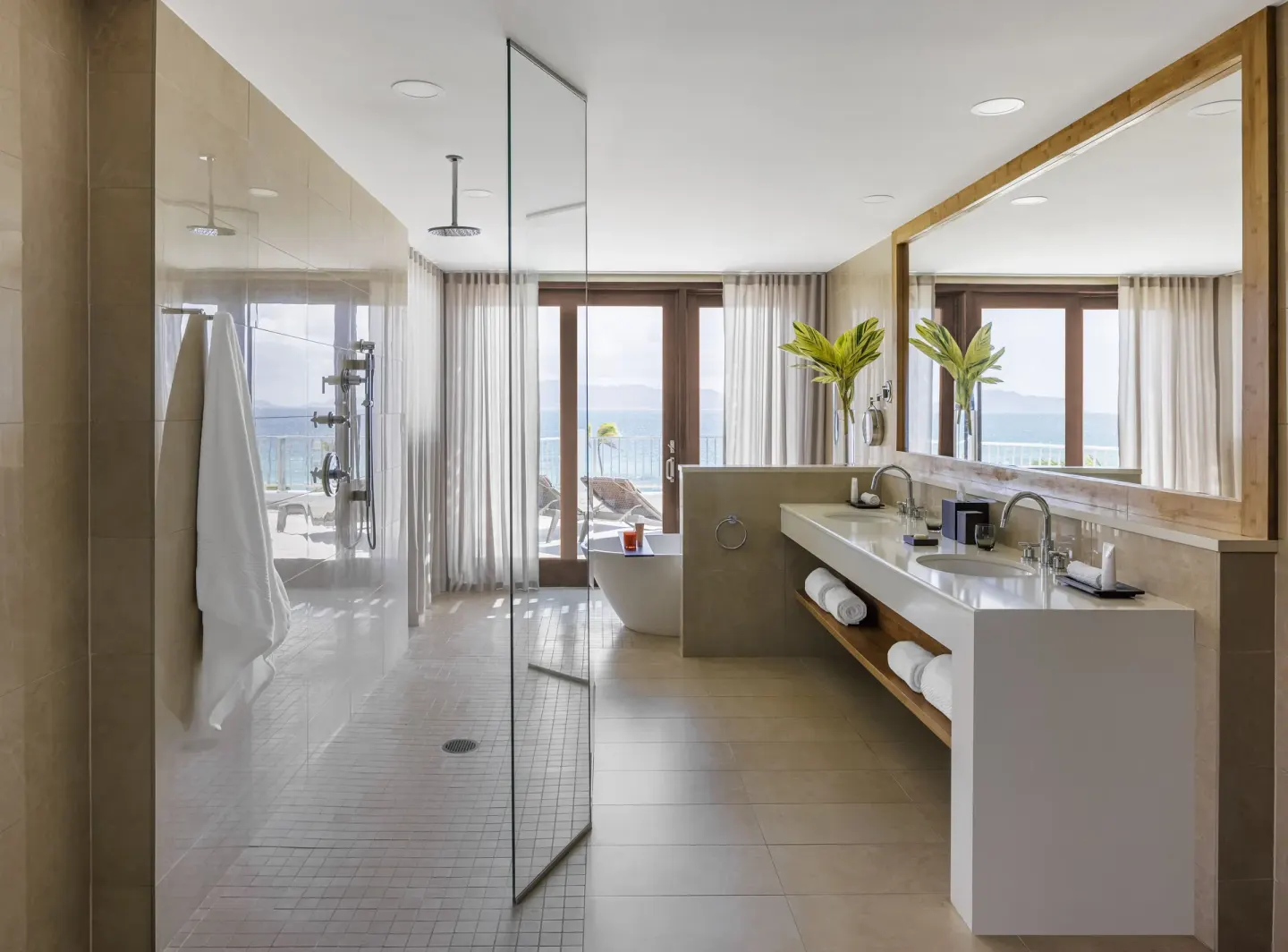 Bathroom with glass shower and double vanity at Aurora Anguilla Resort & Golf Club.
