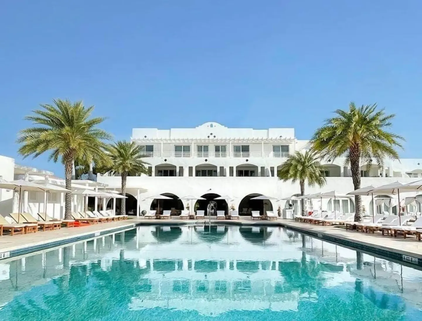Pool and white resort building at Aurora Anguilla Resort & Golf Club.