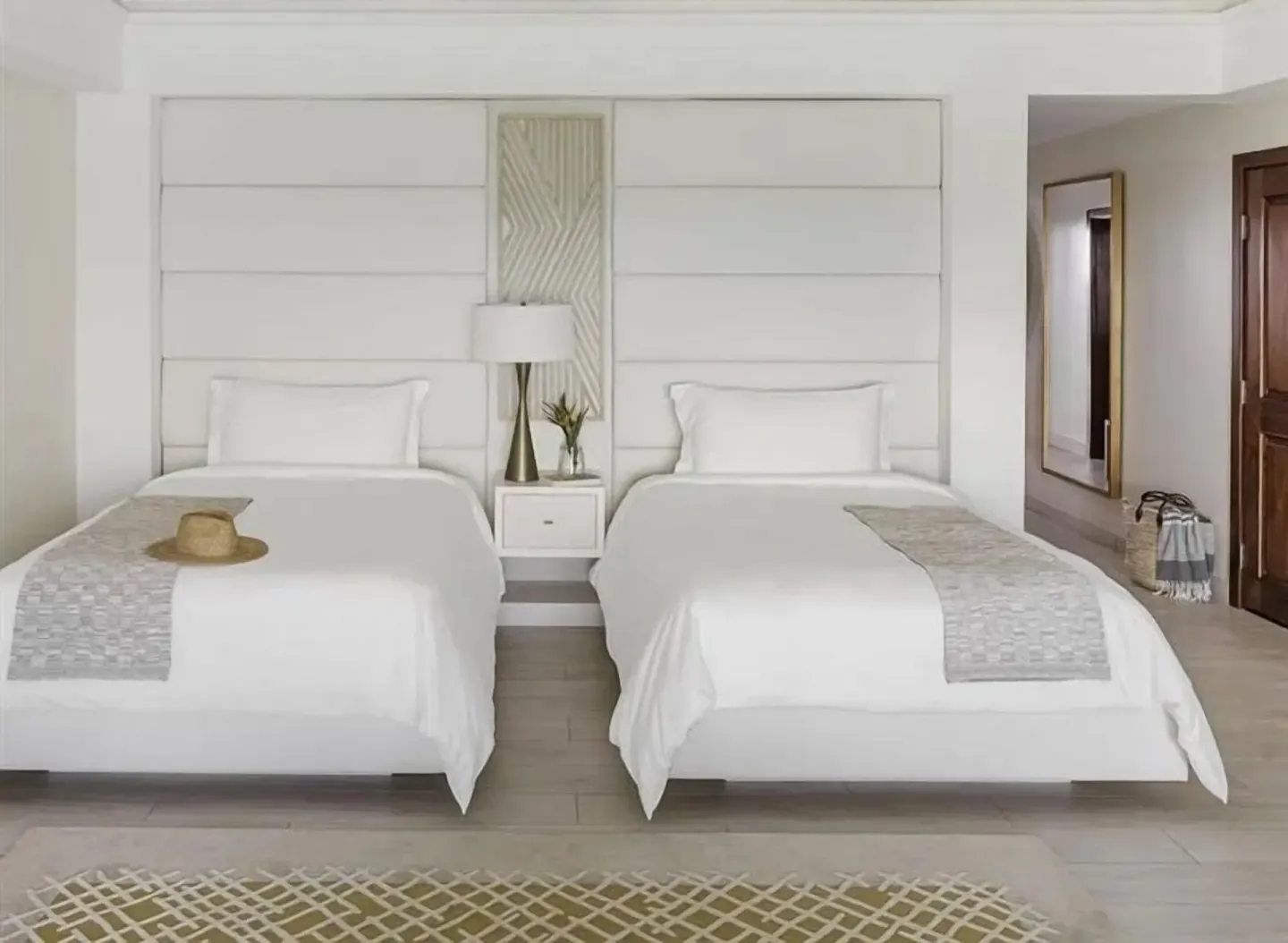 Two beds in a Resort View Junior Suite at Aurora Anguilla Resort & Golf Club.