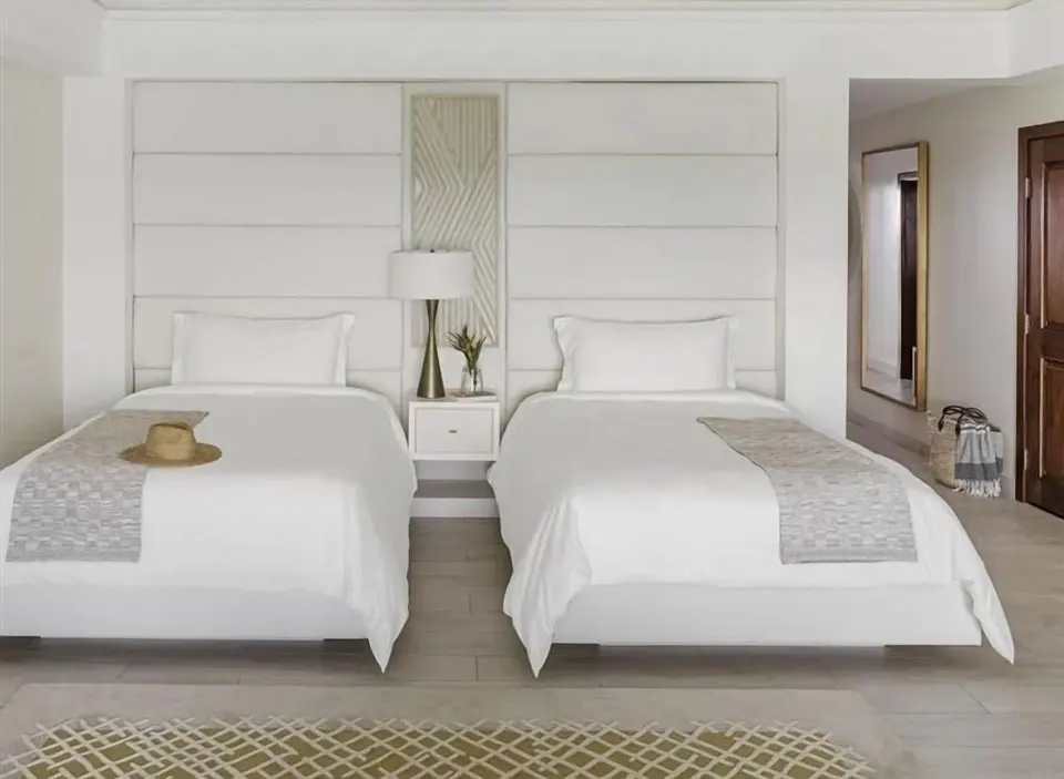 Two beds in a Resort View Junior Suite at Aurora Anguilla Resort & Golf Club.