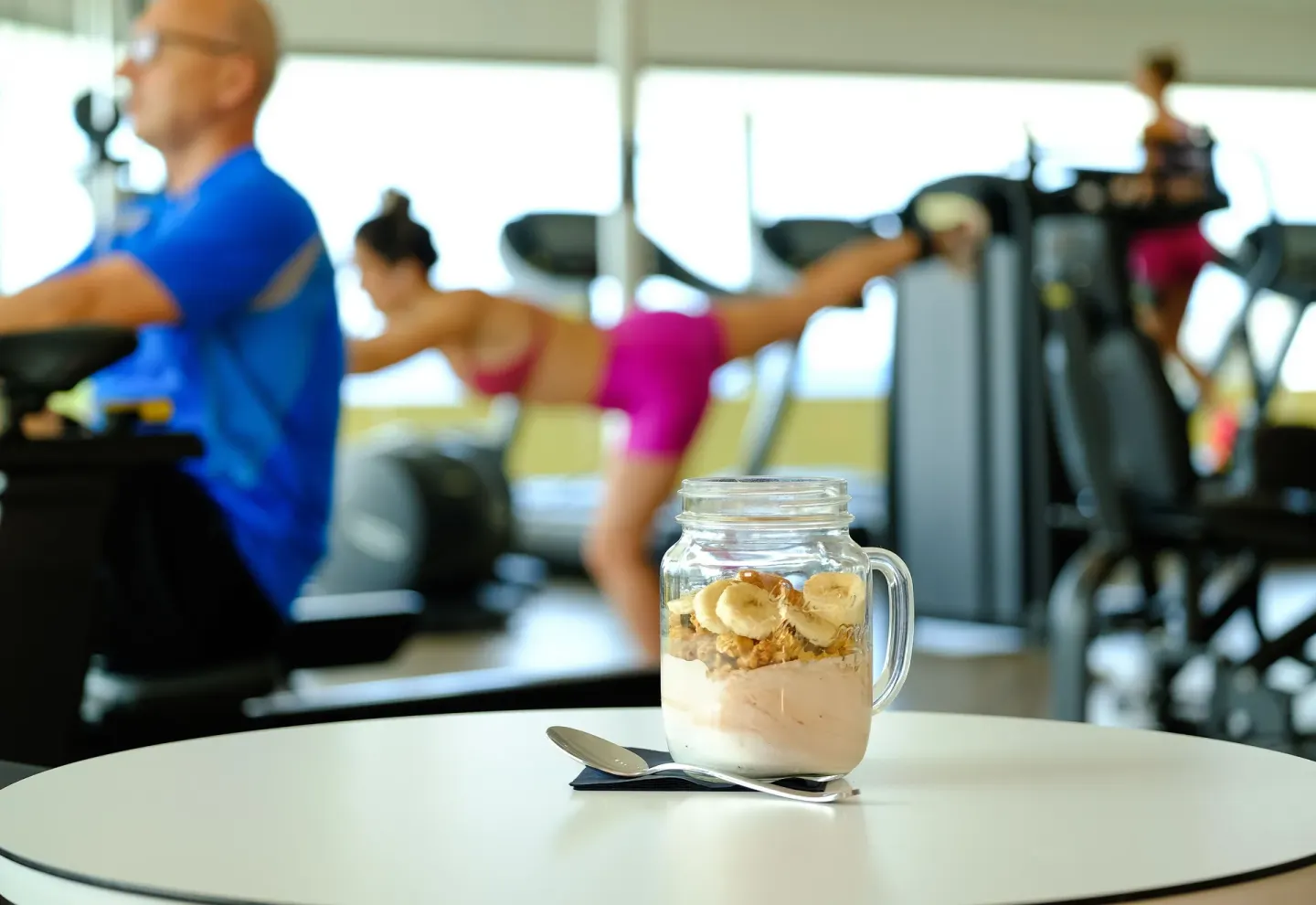 Yogurt jar on a table with gym equipment and exercisers at Avila Beach Hotel.