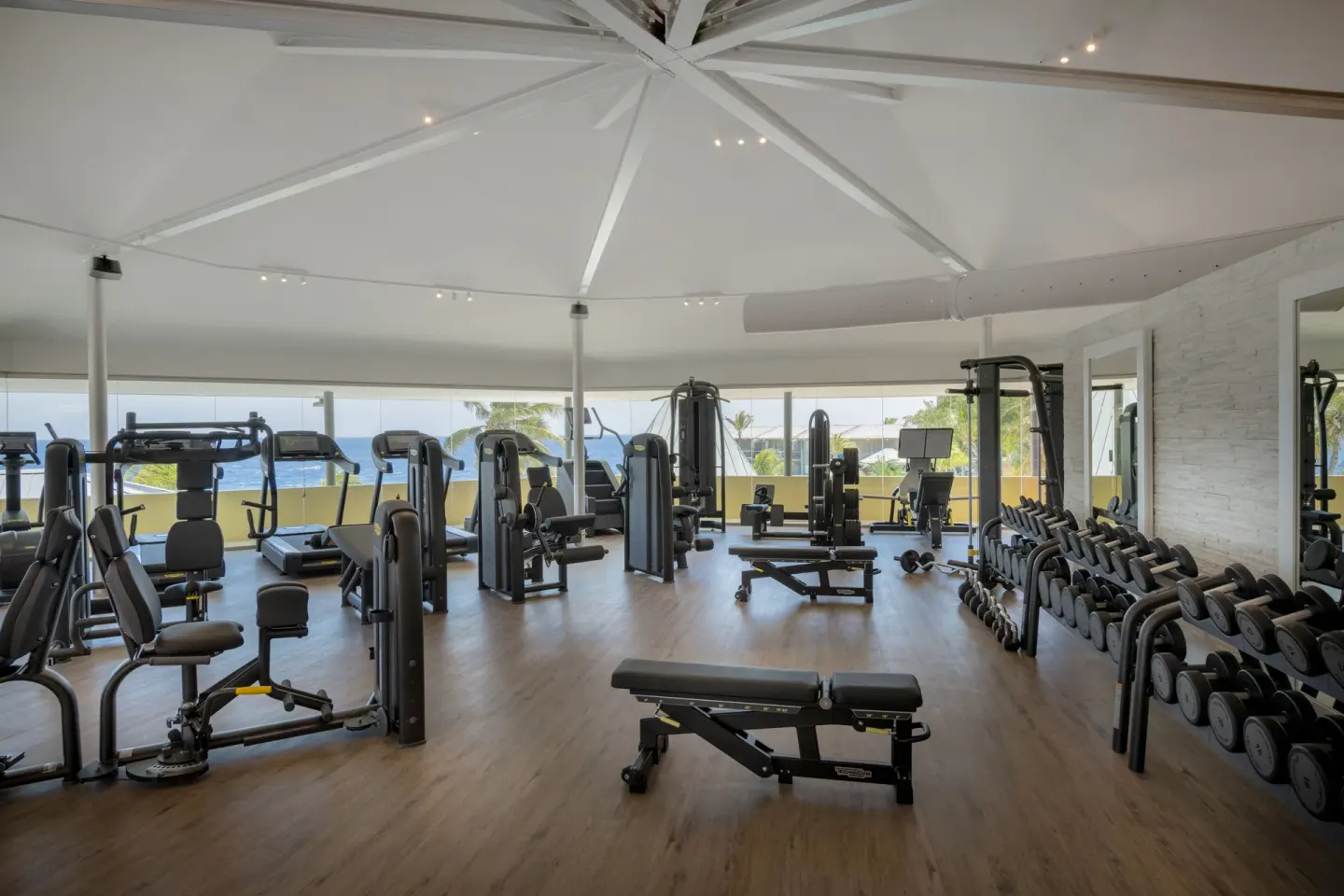 Fitness room with cardio machines, weights, and ocean views at Avila Beach Hotel.