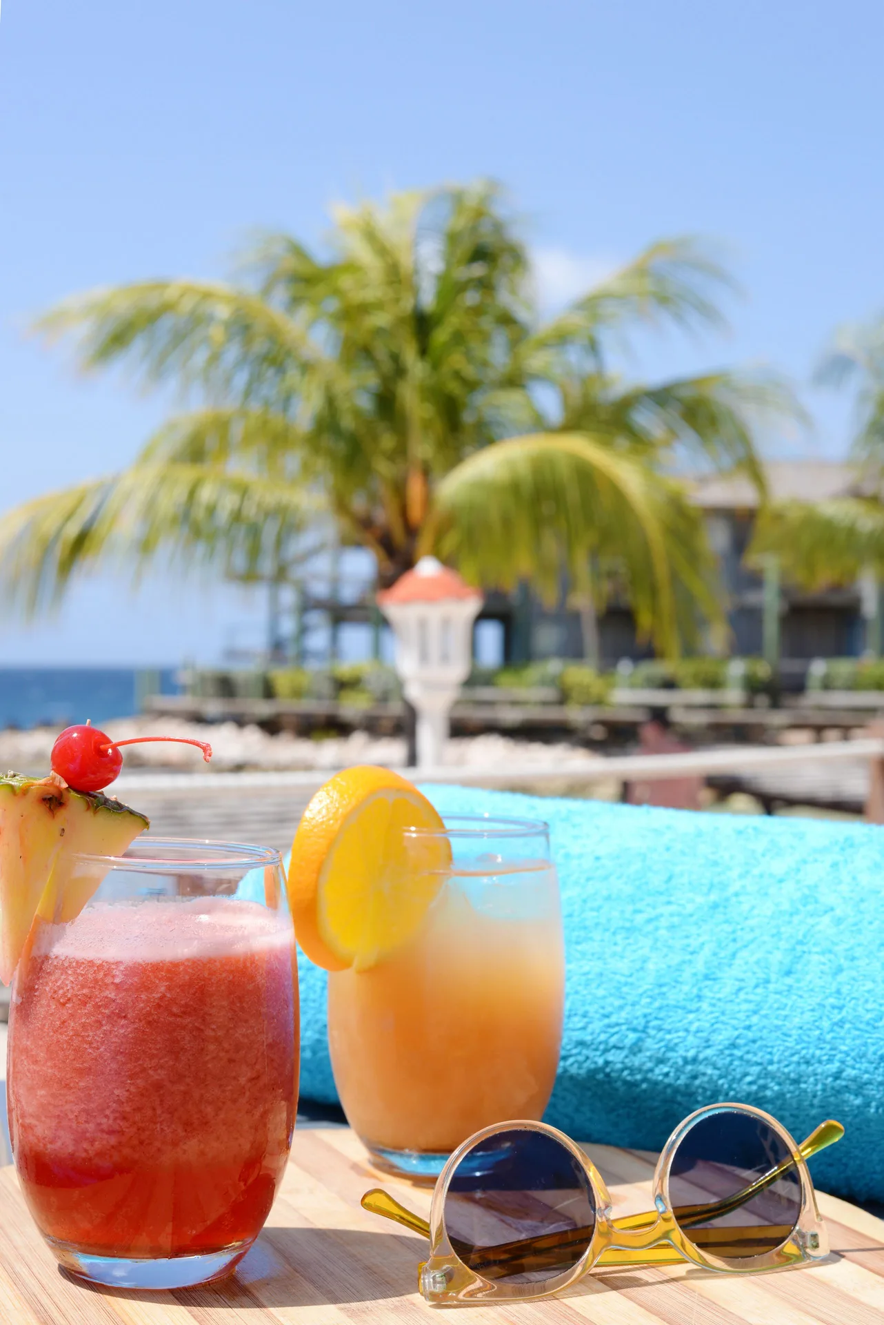 Poolside drinks, sunglasses and towel with palm trees at Avila Beach Hotel.