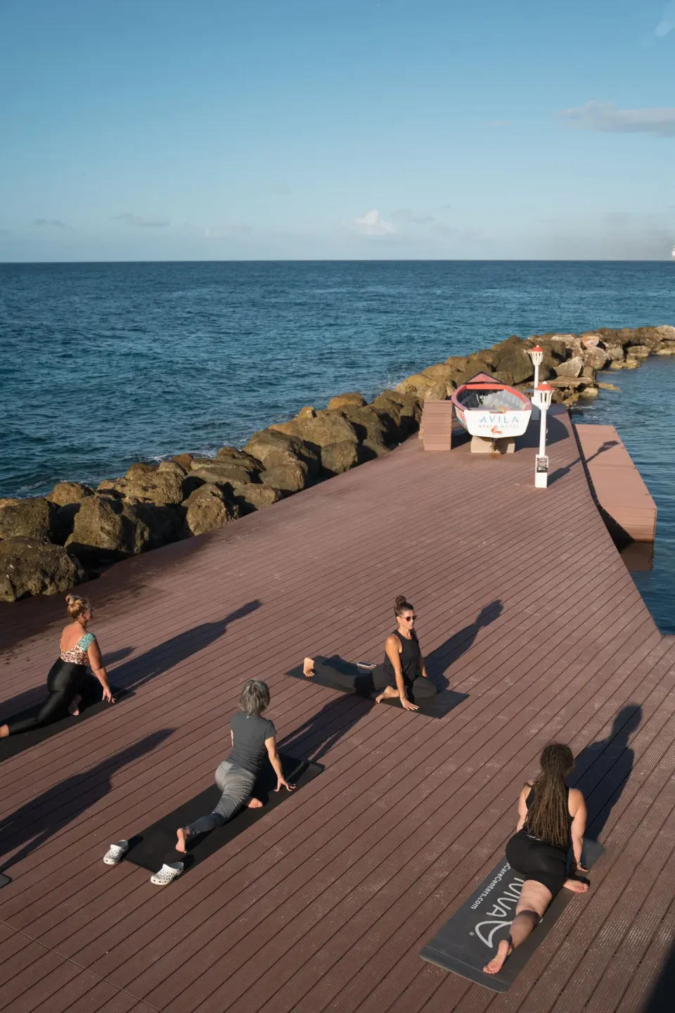 People practicing yoga on a seaside deck at Avila Beach Hotel.
