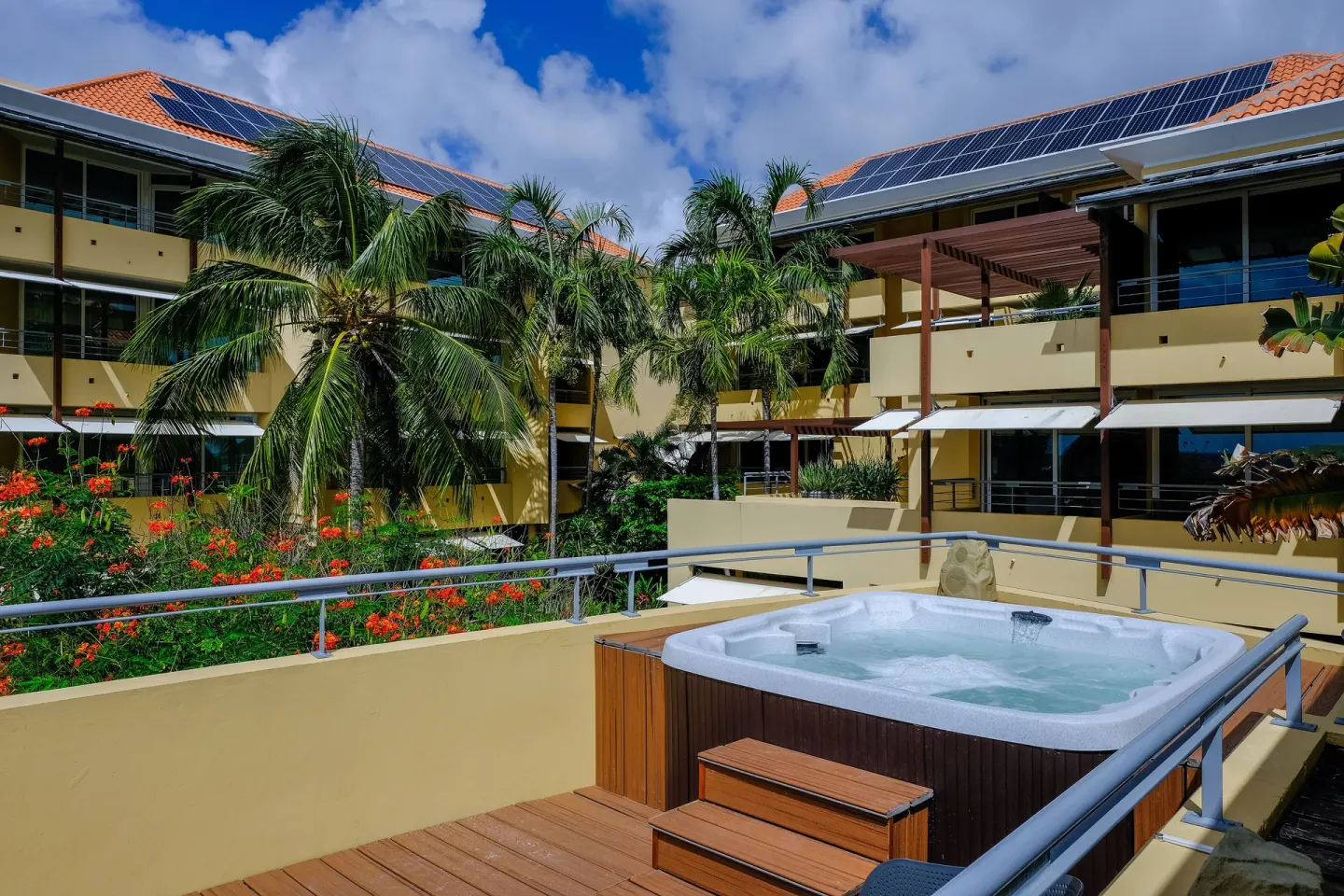 Outdoor hot tub on a terrace among palms and resort buildings at Avila Beach Hotel.
