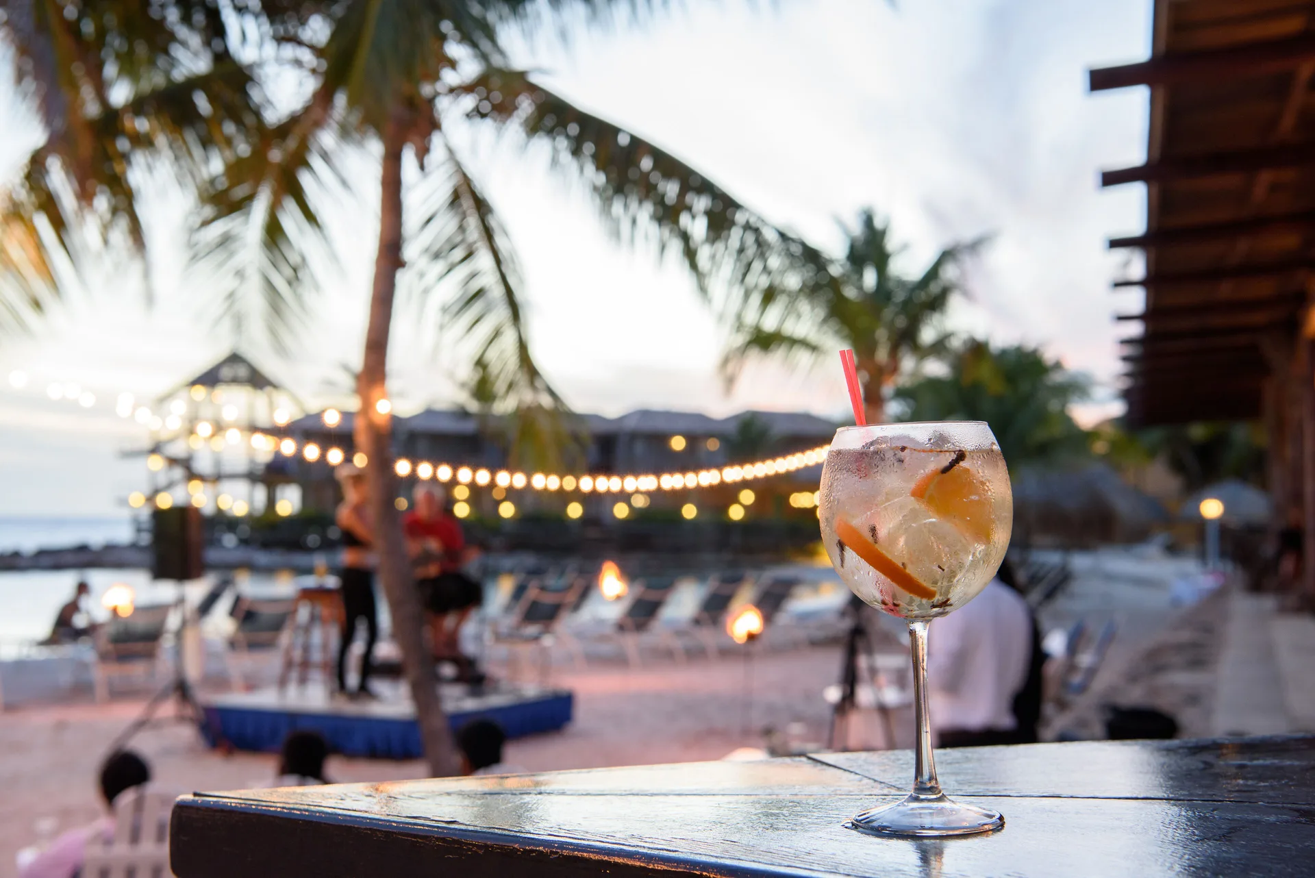 Cocktail on a bar with beach lights and evening seating at Avila Beach Hotel.