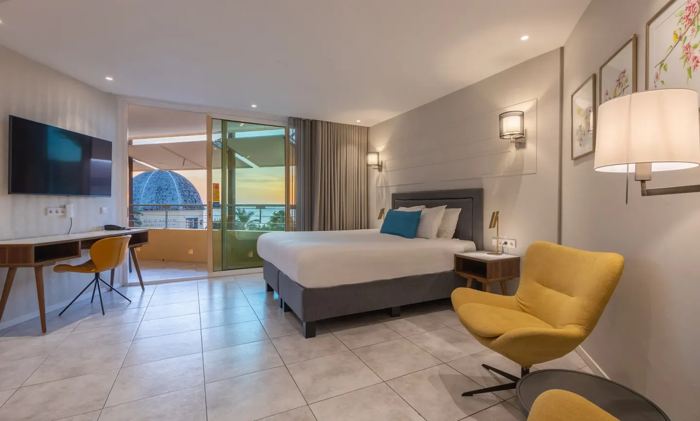 Deluxe Room octagon with king bed, desk, balcony, and sea glimpse at Avila Beach Hotel.