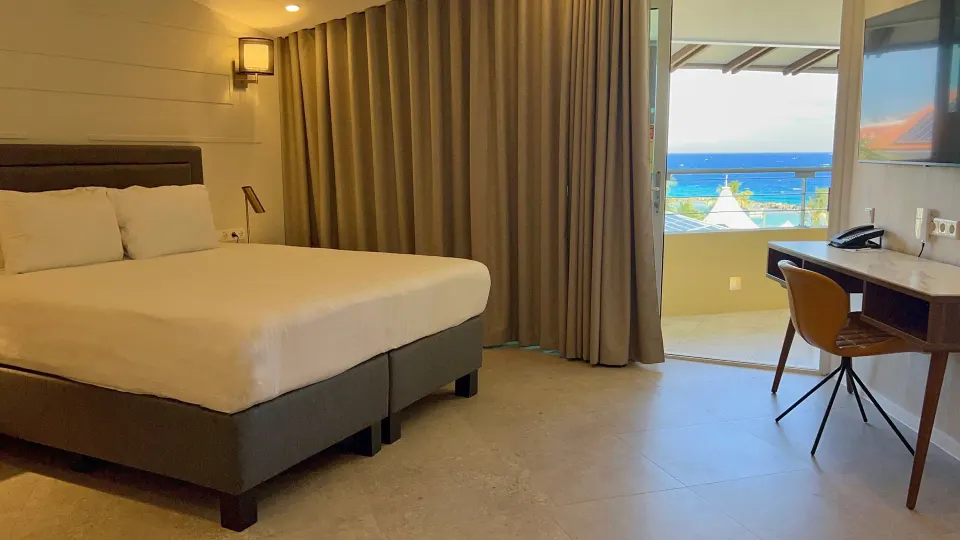 Deluxe Room with king bed, desk, balcony, and ocean view at Avila Beach Hotel.