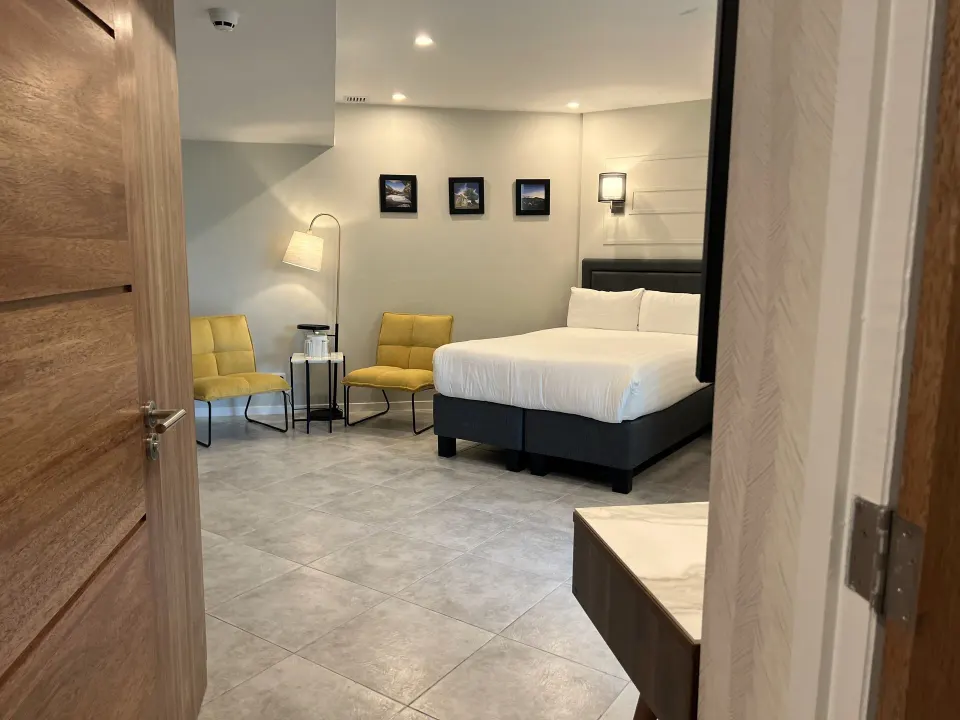 Deluxe Room with king bed and yellow chairs at Avila Beach Hotel.