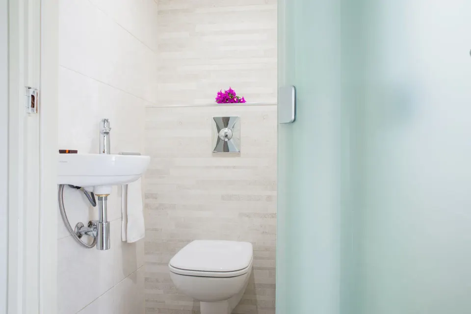 Bathroom toilet and small sink in la Belle Alliance apartment at Avila Beach Hotel.