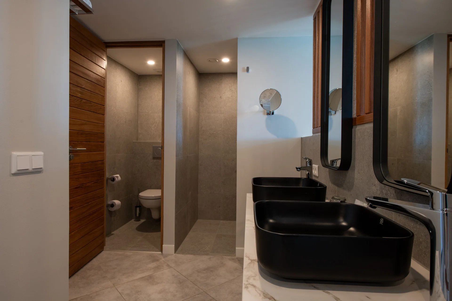 Preferred Room bathroom with twin black vessel sinks and separate toilet area at Avila Beach Hotel.