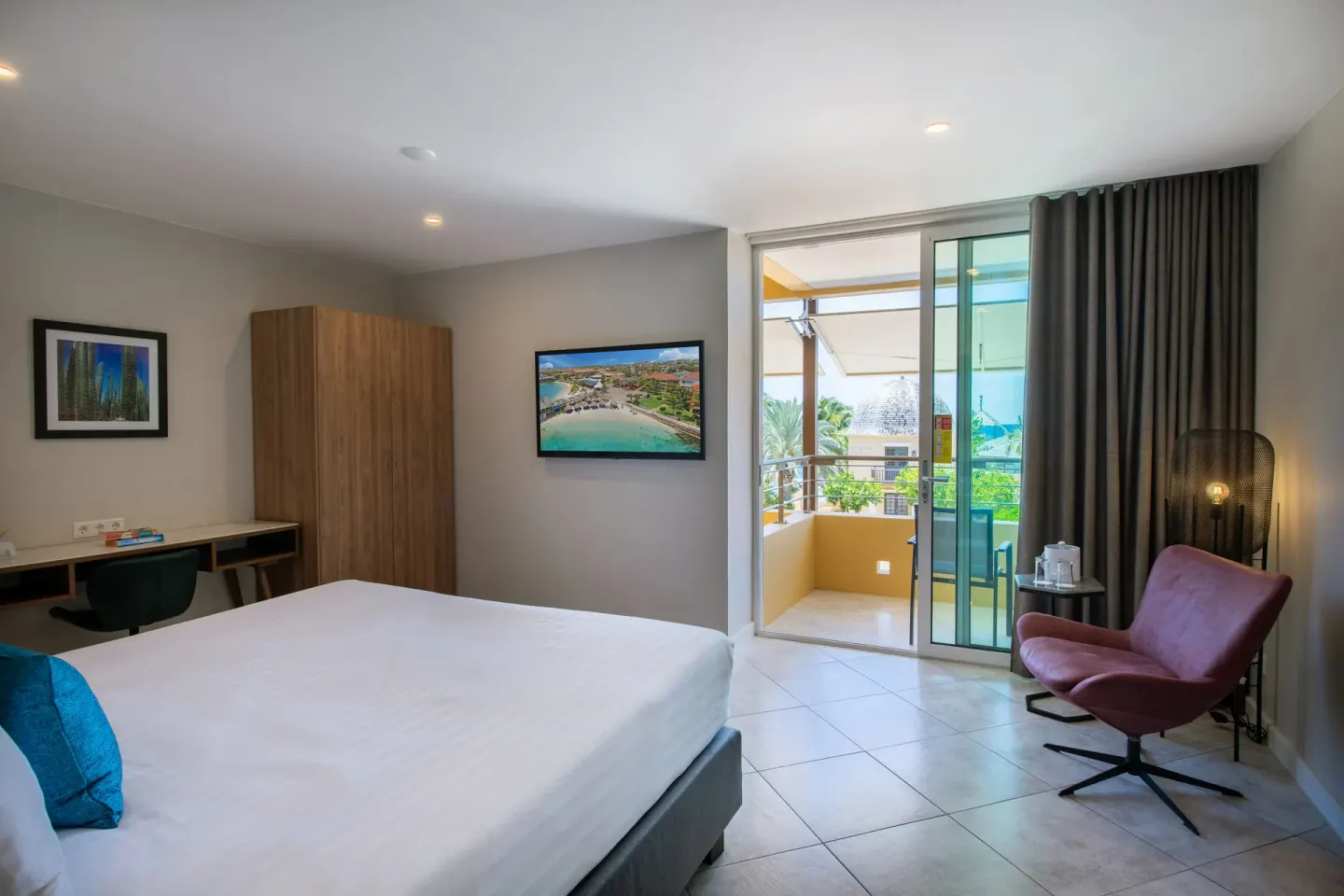 Preferred Room king bed with balcony doors, desk, TV, and lounge chair at Avila Beach Hotel.