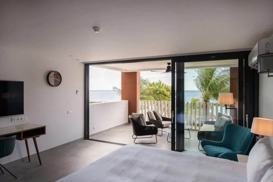 Premium apartment bedroom opening to a balcony with ocean views at Avila Beach Hotel.