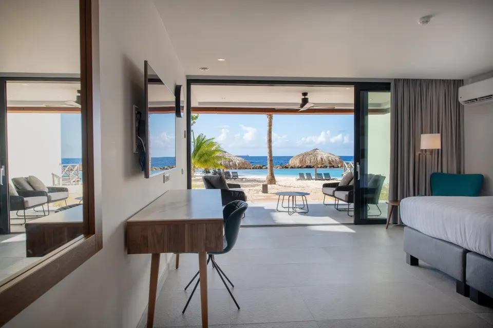 Premium apartment bedroom with desk and beachfront view at Avila Beach Hotel.