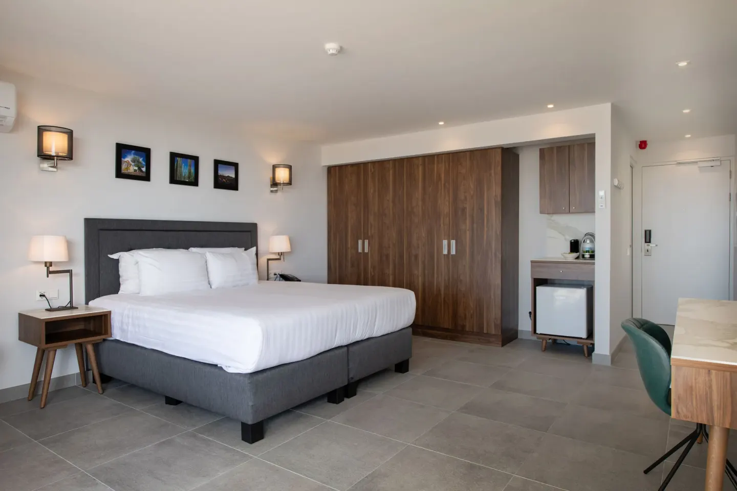 Premium apartment bedroom with bed, wardrobes, desk, and minibar at Avila Beach Hotel.