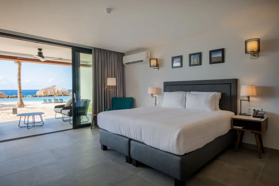 Premium apartment bedroom with king bed and beach terrace at Avila Beach Hotel.