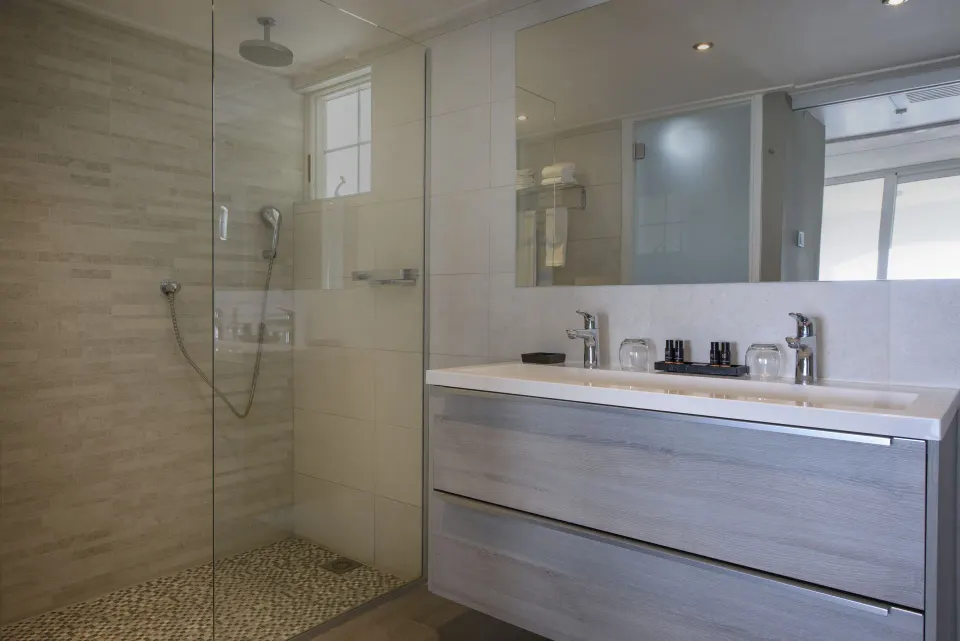Royal Three Bedroom Apartment bathroom with glass shower at Avila Beach Hotel.