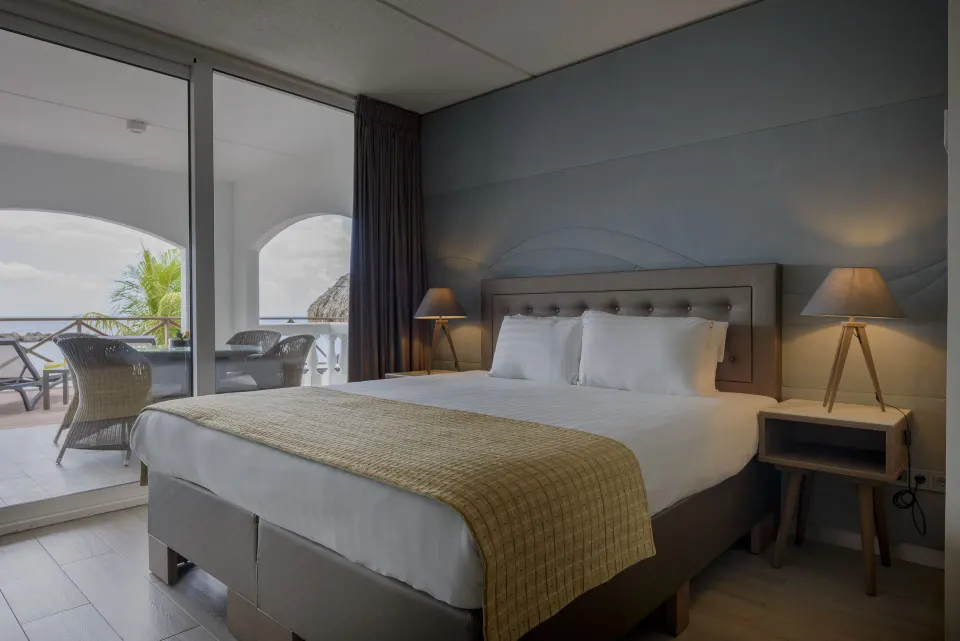 Royal Three Bedroom Apartment king bedroom with balcony at Avila Beach Hotel.