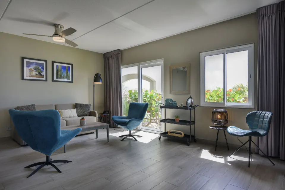 Royal Three Bedroom Apartment living room with blue chairs at Avila Beach Hotel.