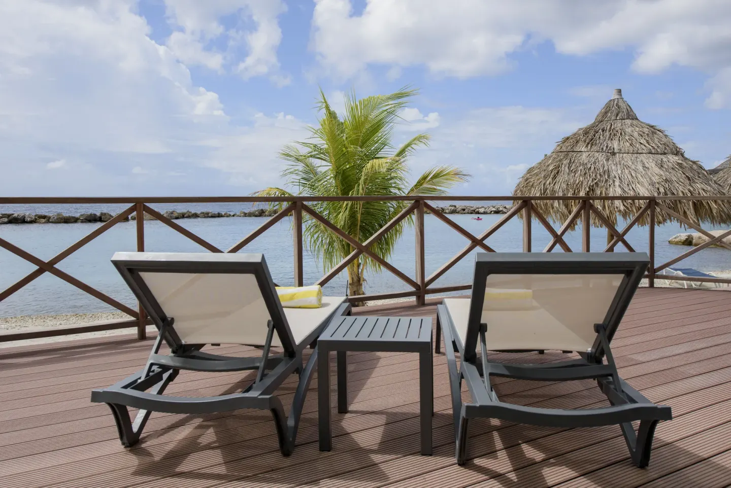 Royal Three Bedroom Apartment terrace loungers by the water at Avila Beach Hotel.