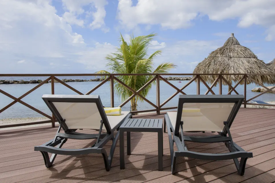 Royal Three Bedroom Apartment terrace loungers by the water at Avila Beach Hotel.