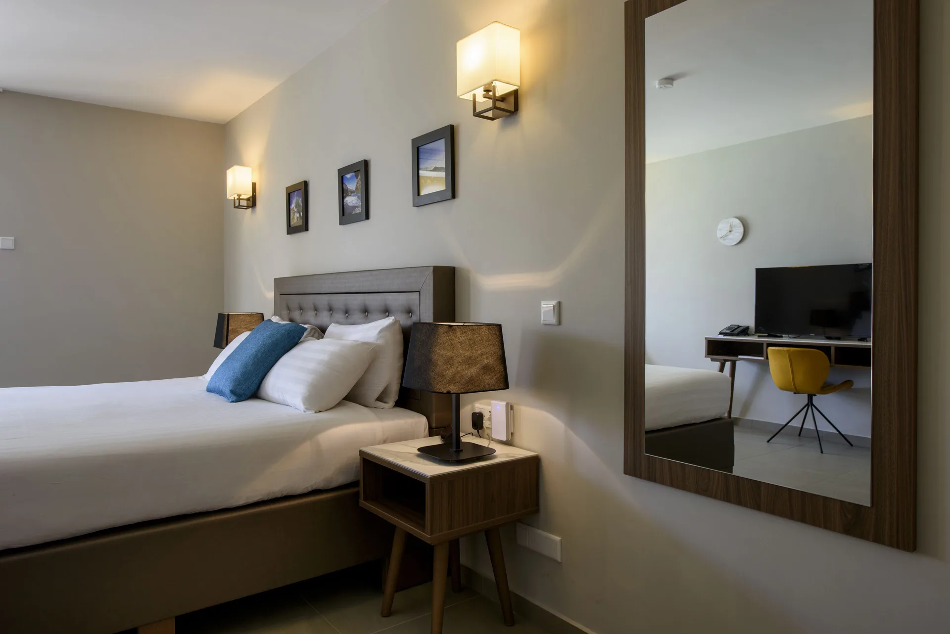 Standard Room bed with nightstand, lamps and wall mirror at Avila Beach Hotel.