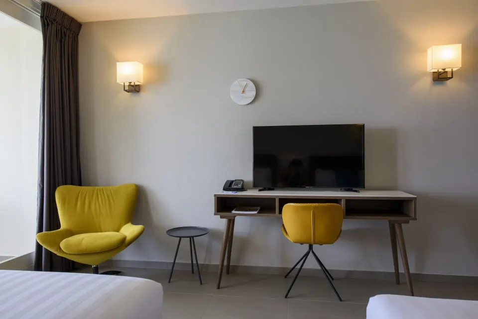 Standard Room TV desk with yellow chair and lounge seating at Avila Beach Hotel.