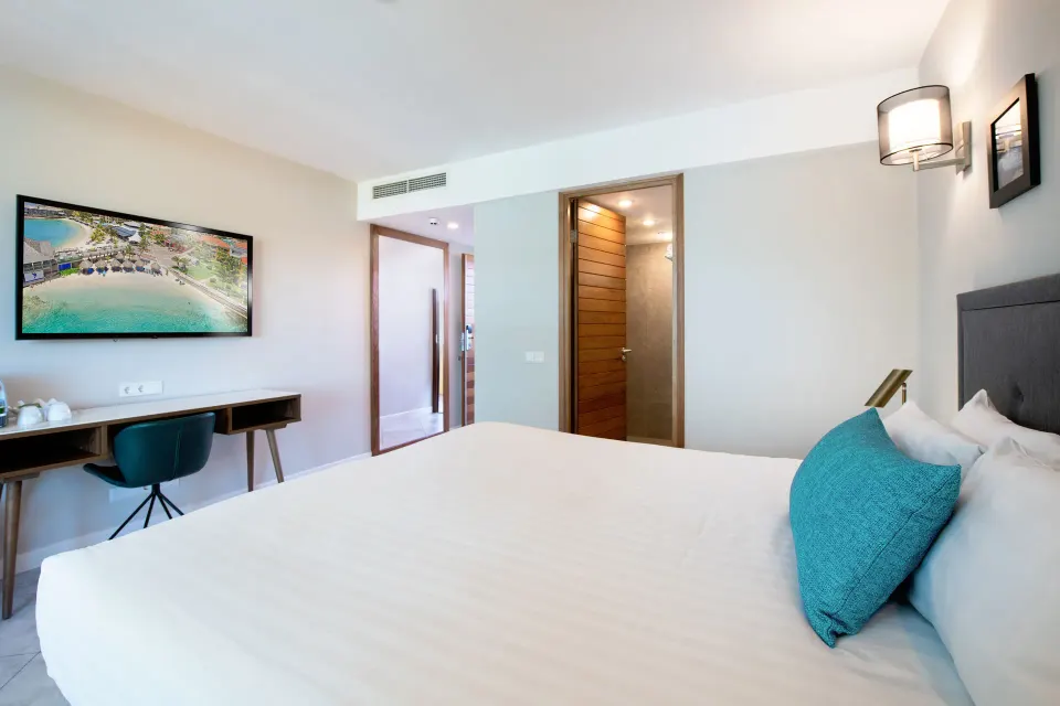 Standard Room king bed facing a desk and wall-mounted TV at Avila Beach Hotel.